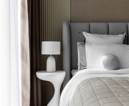 Interior shot of modern luxurious bedroom with side table and lamp